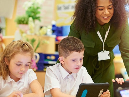 Image of a teacher and two students in a classroom working on as tablet device for the blog on The Nine Steps to Simple Edtech Procurement.